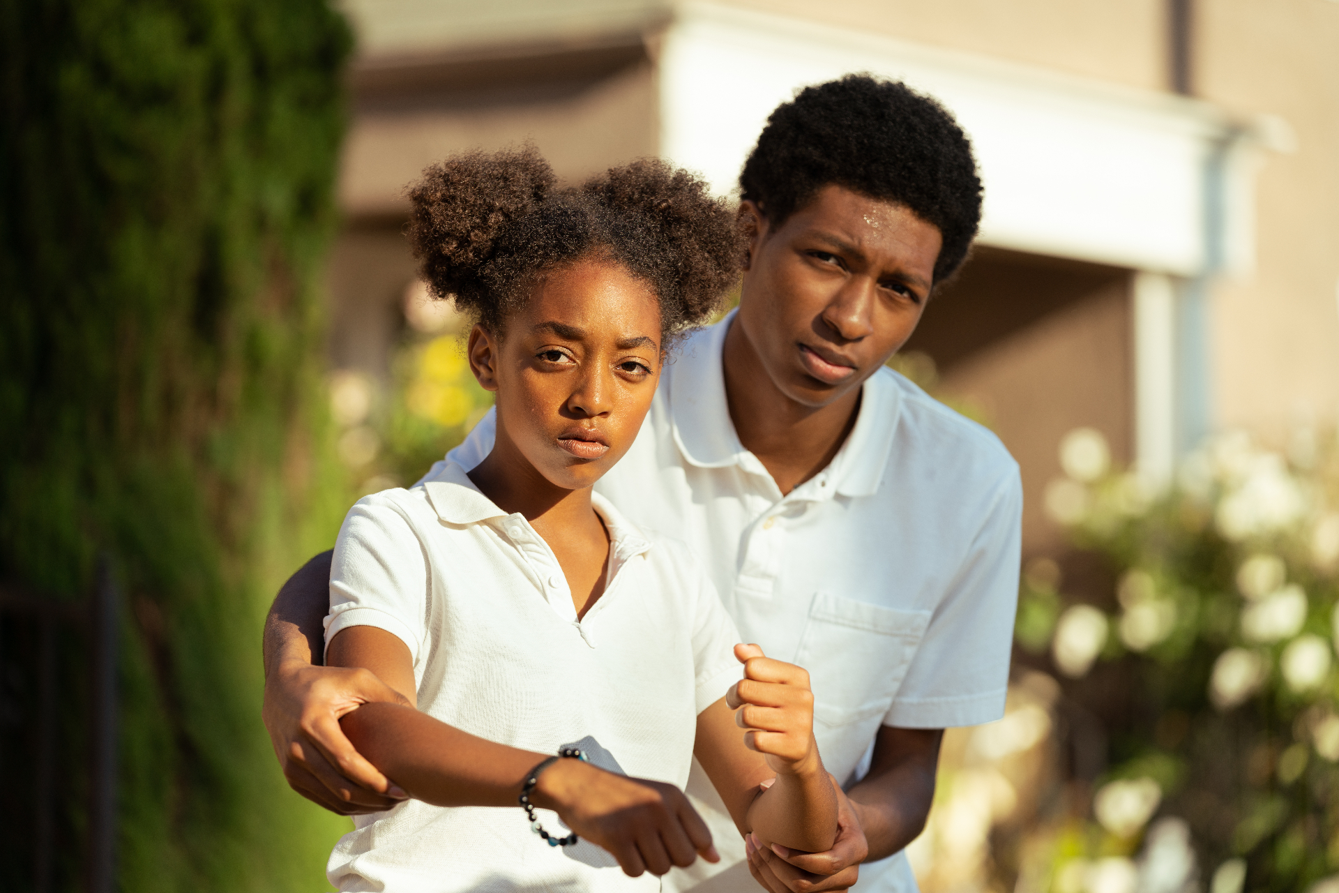 Cherry Lemonade — intimate production still of the two leads, Eris Baker and Skylan Brooks, looking directly into the camera in warm late-afternoon light